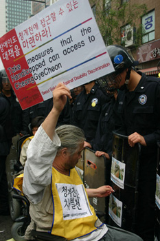 이동권연대 박경석 집행위원장이 장애인도 청계천에 접근할 수 있도록 해달라는 피켓을 들고 있다. 